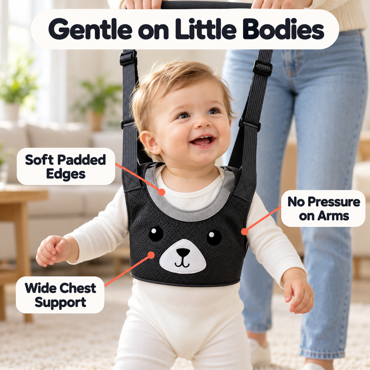 Smiling baby wearing a soft padded black walking harness with wide chest support